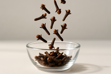 Load image into Gallery viewer, Cloves falling into a glass bowl
